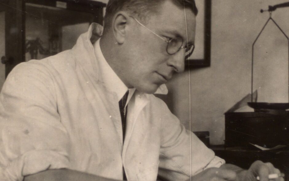 Photograph of F. G. Banting writing at his desk ca. 1926
